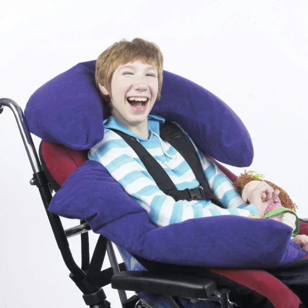 Blue beanbags shown supporting a smiling teenage boy's head and arm as he sits in a wheelchair